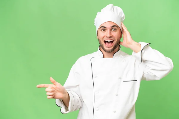 Jonge Knappe Chef Kok Man Geïsoleerde Achtergrond Verrast Wijzend Vinger — Stockfoto