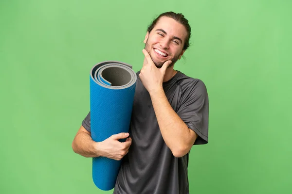 年轻的运动员一边带着垫子 一边带着孤独的背景去上瑜伽课 开心地微笑着 — 图库照片
