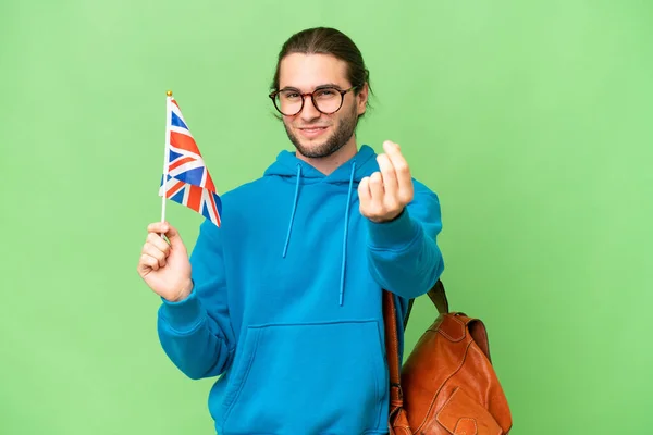 年轻英俊男子举着英国国旗 身披孤立的背景 做着赚钱的手势 — 图库照片