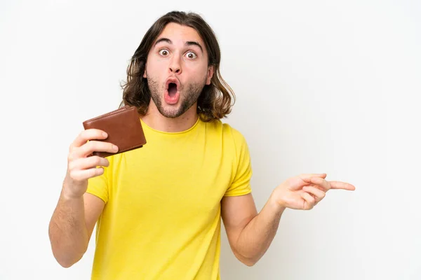 Mladý Pohledný Muž Drží Peněženku Izolované Bílém Pozadí Překvapený Ukazuje — Stock fotografie