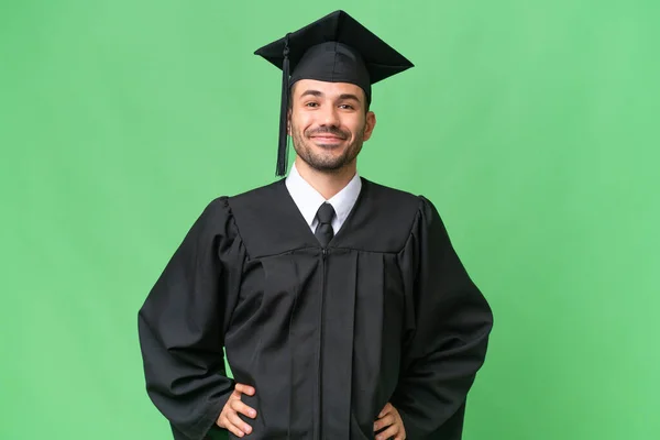 Junger Universitätsabsolvent Mit Isoliertem Hintergrund Posiert Mit Armen Der Hüfte — Stockfoto