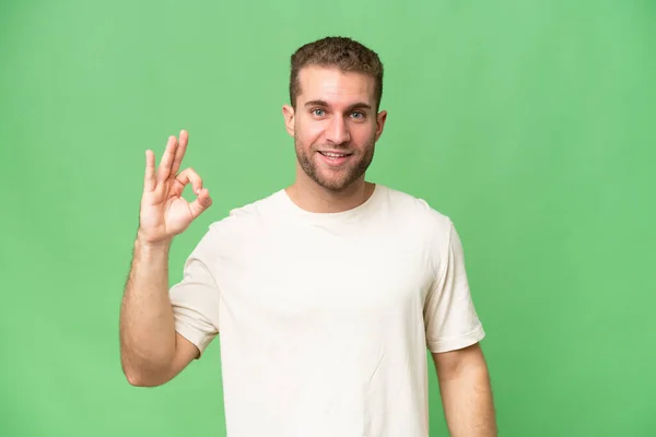 Yeşil Krom Arka Planda Izole Edilmiş Yakışıklı Beyaz Adam Parmaklarıyla — Stok fotoğraf