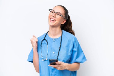 Beyaz arka planda izole edilmiş, telefon zafer pozisyonunda genç, beyaz cerrah kadın.