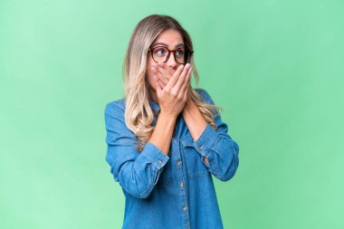 Genç Uruguaylı kadın izole edilmiş arka planda ağzını kapatıyor ve yana bakıyor.