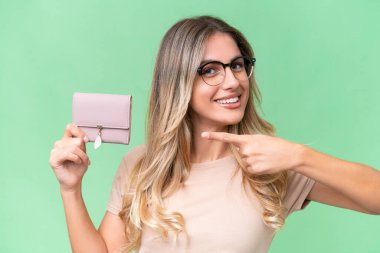 Genç Uruguaylı kadın cüzdanı izole edilmiş arka planda tutuyor ve onu işaret ediyor.