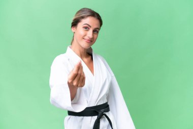 Uruguaylı genç bir kadın izole edilmiş arka planda karate yapıyor. Para hareketi yapıyor.