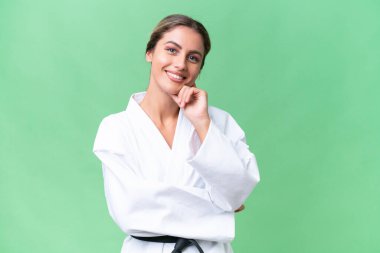 Genç Uruguaylı kadın izole edilmiş arka planda karate yapıyor. Mutlu ve gülümsüyor.