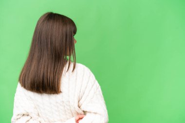 Arka planda izole edilmiş küçük beyaz kız arkasına bakıyor.