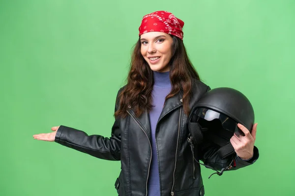若いですCaucasian女性とともにオートバイヘルメット上の隔離された背景伸ばさ手へザ側への招待 — ストック写真