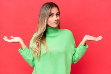 Genç Uruguaylı kadın kırmızı arka planda izole edilmiş.