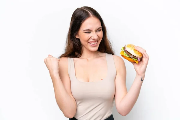 Młoda Kaukaska Kobieta Trzyma Hamburgera Białym Tle Świętując Zwycięstwo — Zdjęcie stockowe