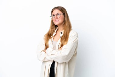 Beyaz arka planda izole edilmiş genç sarışın kadın gülümserken yukarı bakıyor.