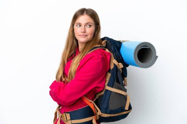 Genç dağcı kız, geniş bir sırt çantasıyla izole edilmiş, kolları bağlı ve mutlu beyaz bir arka planı var.