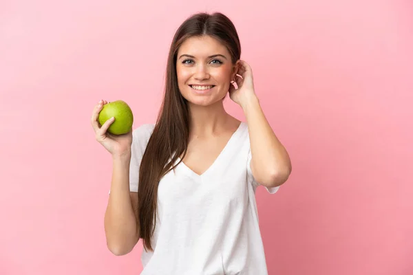 年轻的高加索女人 背景是粉红的 有苹果 很快乐 — 图库照片