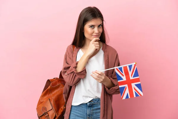 Mladá Běloška Drží Vlajku Spojeného Království Izolované Růžovém Pozadí Dívá — Stock fotografie