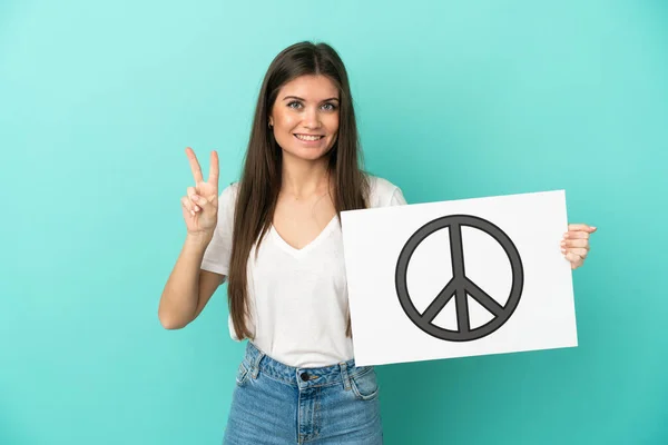 Jovem Caucasiana Isolada Fundo Azul Segurando Cartaz Com Símbolo Paz — Fotografia de Stock