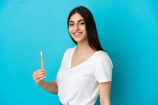 Jovem Mulher Caucasiana Escovação Dentes Isolados Fundo Azul Sorrindo Muito — Fotografia de Stock