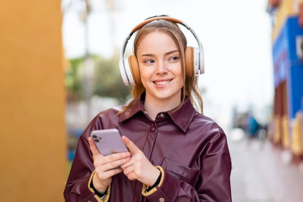 Jeune Jolie Fille Extérieur Écouter Musique Avec Mobile Regarder Devant — Photo