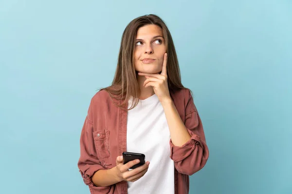 Giovane Donna Slovacca Isolato Sfondo Blu Utilizzando Telefono Cellulare Pensando — Foto Stock
