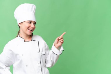 Genç aşçı kadın izole edilmiş yeşil arka plan 