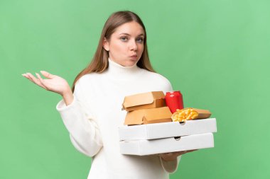 Sarışın, güzel bir kadın arka planda yemek servisi yapıyor. Şüpheleri var ve ellerini kaldırıyor.