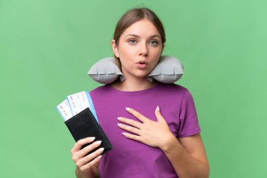 Şişirilebilir seyahat yastığıyla genç ve güzel sarışın kadın izole bir arka plan üzerinde şaşırmış ve şaşırmış görünüyor.