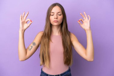 Genç Litvanyalı kadın, mor arka planda Zen pozuyla izole edilmiş.