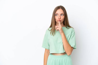 Beyaz arka planda izole edilmiş genç Litvanyalı kadın parmağını ağzına koyan sessiz bir jest işareti gösteriyor.