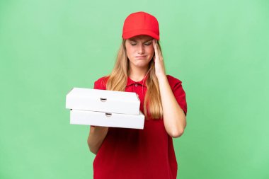 İş üniformalı beyaz pizza teslimatçısı kadın izole edilmiş arka plandan pizza kutuları alıp baş ağrısı çekiyor.