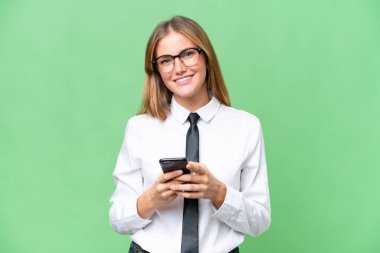 Kafkasyalı genç bir kadın izole edilmiş arka planda cep telefonuyla mesaj gönderiyor.