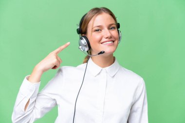 Kafkasyalı bir kadın tele pazarlamacı, izole bir geçmişi olan bir kulaklıkla çalışıyor ve onu işaret ediyor.