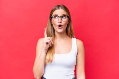 Genç ve güzel bir kadın, kırmızı arka planda izole edilmiş.