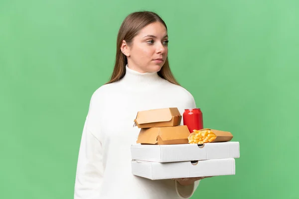 Young Beautiful Blonde Woman Holding Takeaway Food Isolated Background Looking — Stock Photo, Image