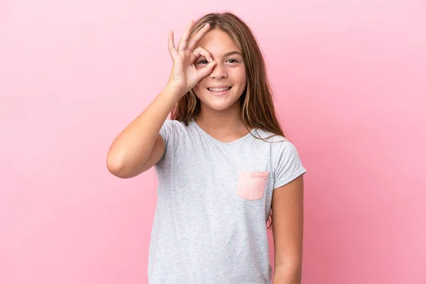 ピンクの背景に孤立した小さなCaucasian女の子ショーOk Signとともに指 — ストック写真