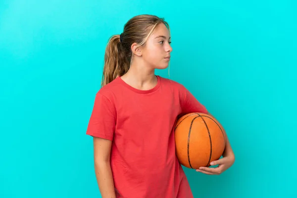 Little Caucasian Girl Playing Basketball Isolated Blue Background Looking Side — Stock Photo, Image