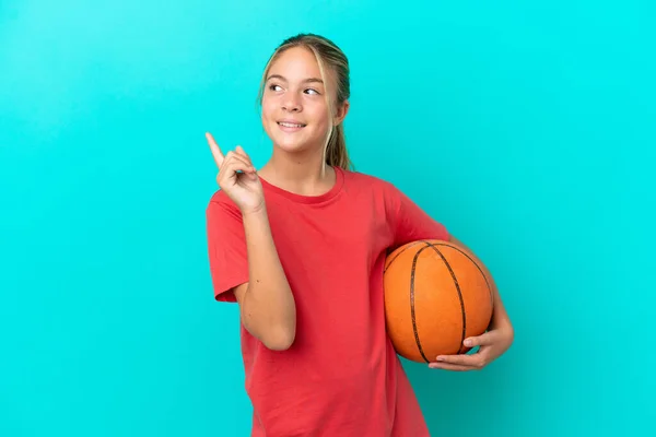 小さいですCaucasian女の子遊びバスケットボール孤立した上に青の背景を指す素晴らしいアイデア — ストック写真