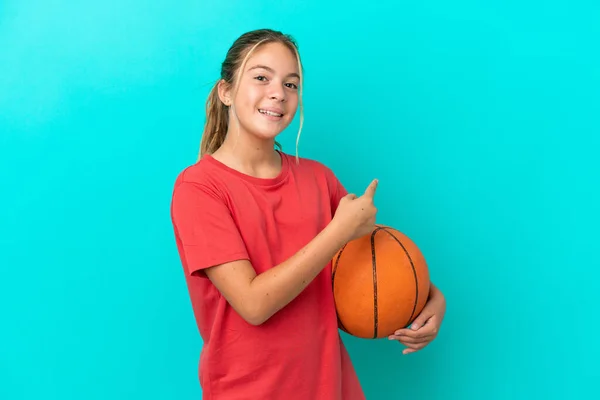 Klein Blank Meisje Spelen Basketbal Geïsoleerd Blauwe Achtergrond Wijzend Terug — Stockfoto