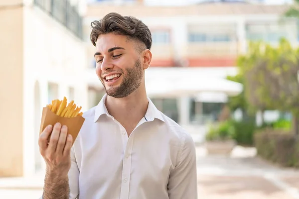 Jonge Knappe Man Met Gebakken Chips Buitenlucht Met Vrolijke Uitdrukking — Stockfoto
