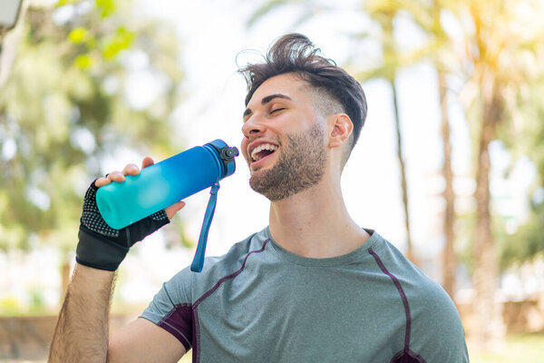 Young handsome man doing sport with a bottle of water