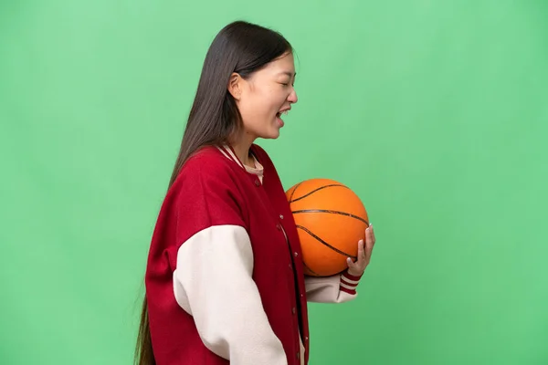 Jonge Basketbalspeler Aziatische Vrouw Geïsoleerde Achtergrond Lachen Laterale Positie — Stockfoto