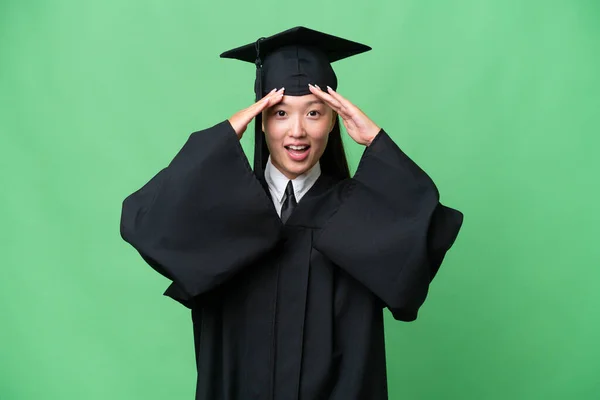 Young university graduate Asian woman over isolated background with surprise expression