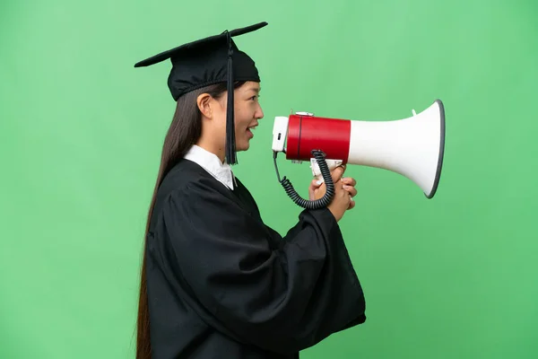 stock image Young university graduate Asian woman over isolated background shouting through a megaphone