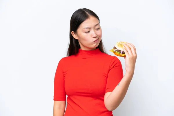 Young Asian Woman Holding Burger Isolated White Background Sad Expression — Zdjęcie stockowe