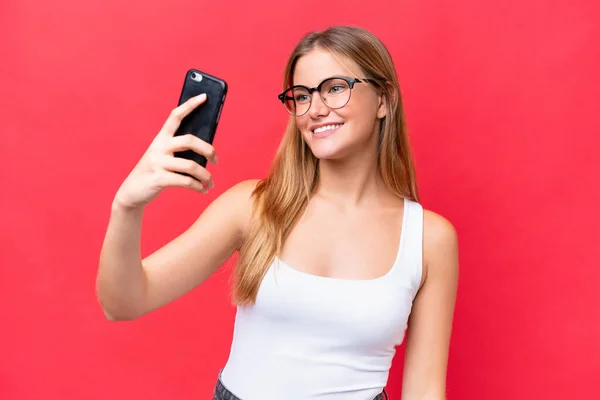 Kırmızı Arka Planda Izole Edilmiş Güzel Bir Kadın Selfie Çekiyor — Stok fotoğraf
