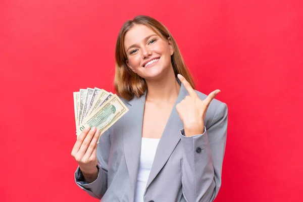 Young Business Caucasian Woman Holding Money Isolated Red Background Giving — Φωτογραφία Αρχείου
