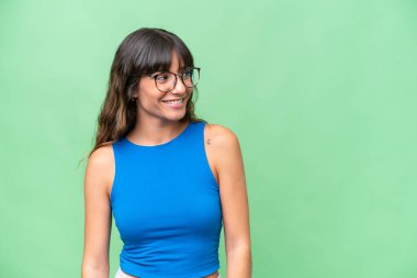 Kafkasyalı genç bir kadın soyutlanmış arka planda, yana bakıyor ve gülümsüyor.