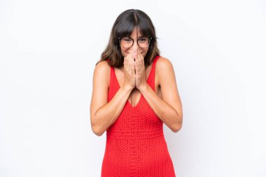 Beyaz arka planda izole edilmiş genç beyaz bir kadın mutlu ve gülümseyen elleriyle ağzını kapatıyor.