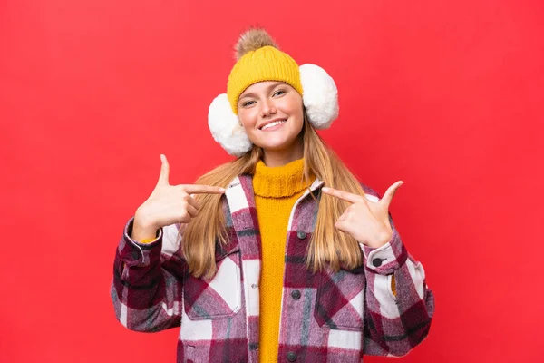 Junge Schöne Frau Trägt Wintermuffs Isoliert Auf Rotem Hintergrund Stolz — Stockfoto