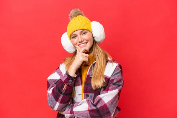 Junge Schöne Frau Trägt Wintermuffs Isoliert Auf Rotem Hintergrund Lächelnd — Stockfoto