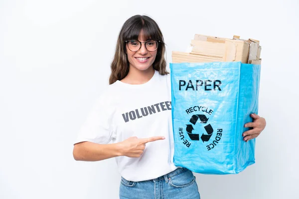 白地に隔離された紙をリサイクルするためにリサイクルバッグを持っている若い白人女性とそれを指す — ストック写真